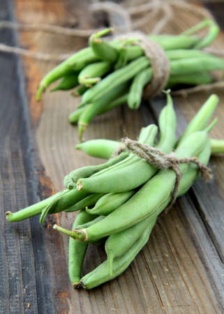 pods of green peas on a wooden table