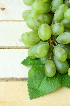 branch of green grapes on a wooden background