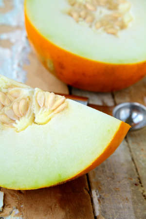Honey yellow melon  on a wooden tableの写真素材