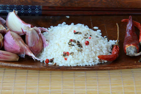 Wooden cup Asian food ingredients - rice, garlic, chiliの写真素材