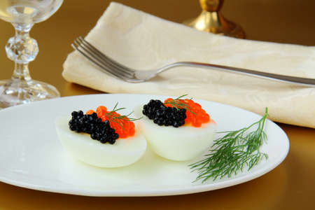 Boiled eggs with red and black caviar の写真素材