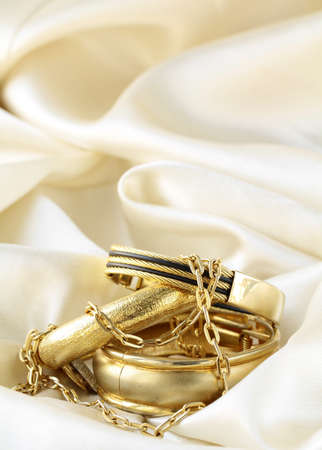 gold jewelry, bracelets and chains on silk の写真素材