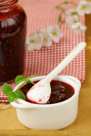 raspberry jam on a wooden table, rustic style