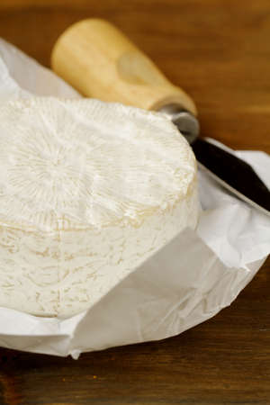 Cheese camembert on a wooden table and a special knife