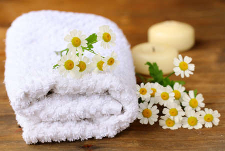 white towel with daisies on a wooden tableの写真素材