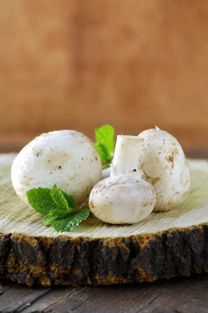 mushrooms champignon on a wooden tableの写真素材