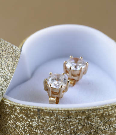 gold earrings stud with diamonds in a gold boxの写真素材