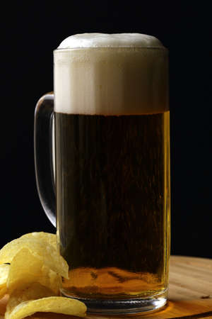 light beer and potato chips on a wooden boardの写真素材