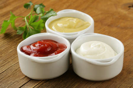 mustard, ketchup and mayonnaise - three kinds of sauces の写真素材