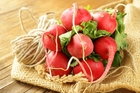 Bunch of fresh organic radishes on a wooden tableの写真素材