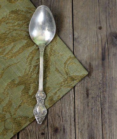vintage silver cutlery spoon on a wooden backgroundの写真素材
