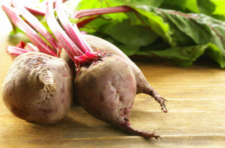  fresh organic beets with leaves on a wooden background