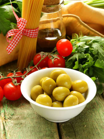 still life of green  marinated olives,  herbs, cherry tomatoes の写真素材