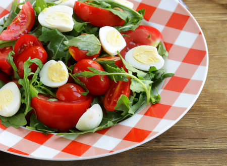 salad with fresh tomatoes, arugula and quail eggsの写真素材