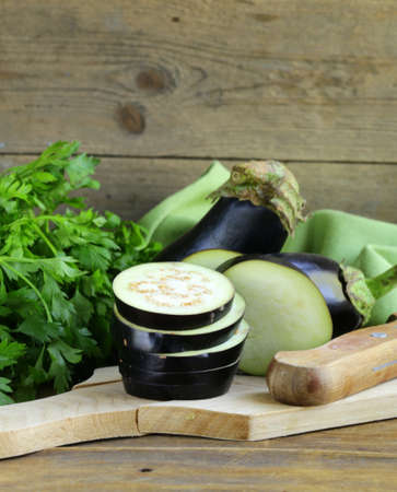 organic vegetables eggplant on a wooden chopping boardの写真素材