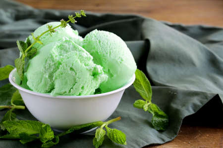 balls mint ice cream with fresh green herbの写真素材