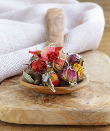 herbal tea from the dried flower buds of roses in a wooden spoonの写真素材