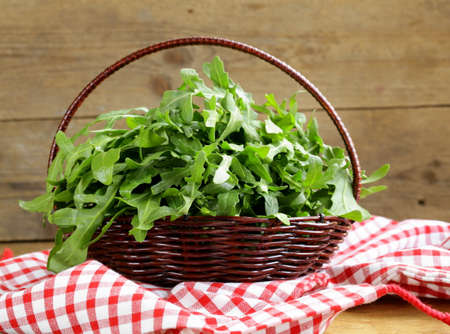 large bunch of arugula green salad on a wooden tableの写真素材
