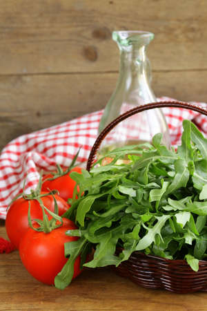 large bunch of arugula green salad on a wooden tableの写真素材