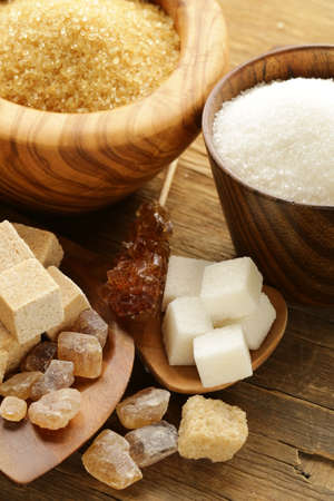 different kinds of sugar - brown, white, refined sugar on a wooden backgroundの写真素材
