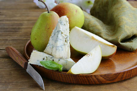 Blue cheese and pears on a wooden plateの写真素材