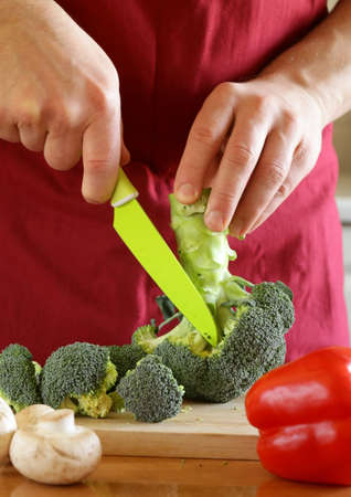 hand man chef cooking vegetable salad on wooden tableの写真素材