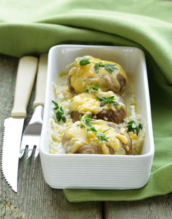 mushrooms baked with cheese, thyme served  on a wooden tableの写真素材