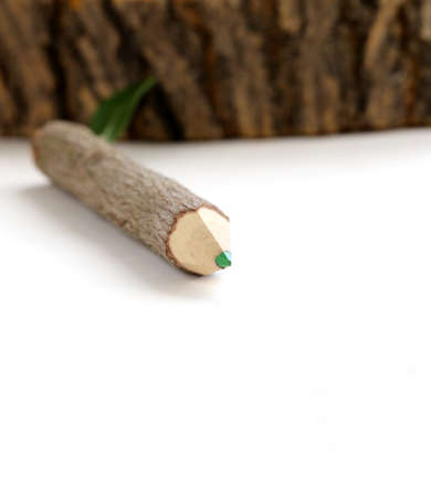 natural wooden pencil with green leaf on white backgroundの写真素材