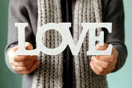  man holding the wooden word love soft focus on the lettersの写真素材
