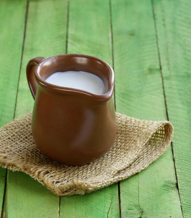 jug with milk on wooden table rustic still lifeの写真素材