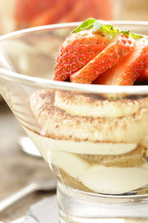 Italian dessert tiramisu decorated with strawberries in a glass beakerの写真素材