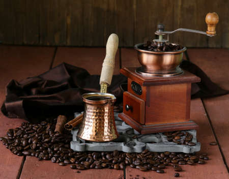 copper coffee pot with beans on a wooden tableの写真素材