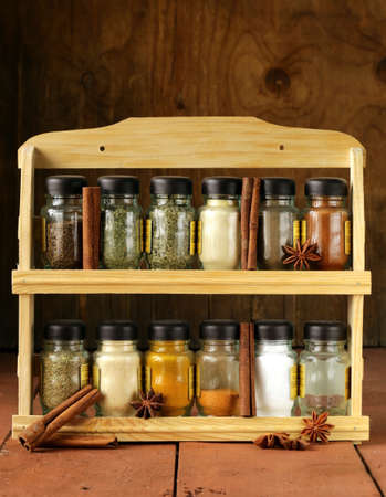 different set of spices in glass jars on wooden shelfの写真素材