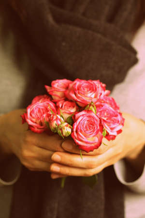 bouquet of pink roses in female hands  toning in retro style の写真素材