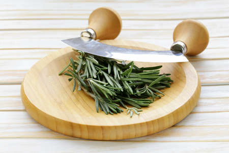 Fresh fragrant green rosemary on a cutting boardの写真素材