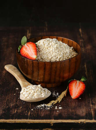 organic oat flakes with strawberries on a wooden table, a healthy dietの写真素材