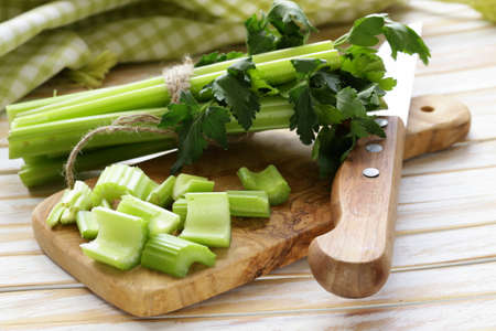 chopped green celery on a kitchen wooden boardの写真素材