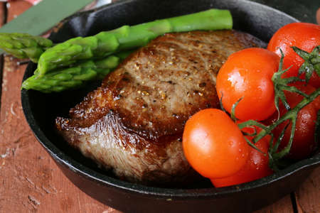 grilled meat beef steak with vegetable garnish  asparagus and tomatoes の写真素材