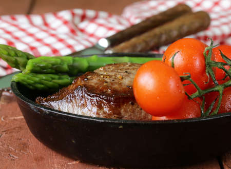 grilled meat beef steak with vegetable garnish  asparagus and tomatoes の写真素材