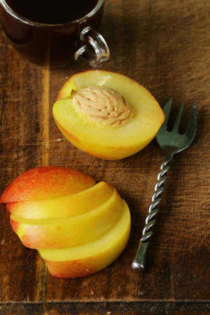 chopped fresh peach with a cup of coffee for breakfastの写真素材