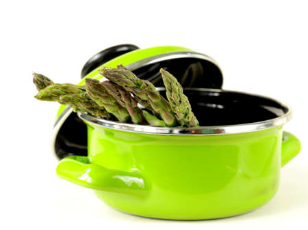 fresh green asparagus in a pot on a white backgroundの写真素材