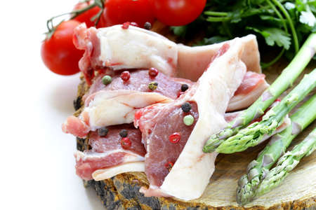 raw meat, lamb chops with vegetables on wooden boardの写真素材