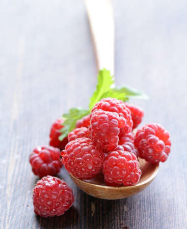 juicy ripe red berry raspberries on wooden backgroundの写真素材