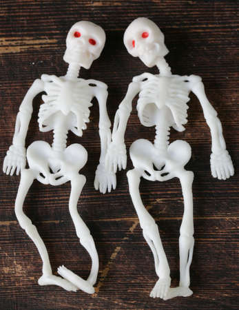 two funny skeleton on a black wooden boardの写真素材