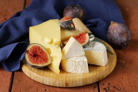 cheeseboard with maasdam, camembert, cheddar cheese and figsの写真素材