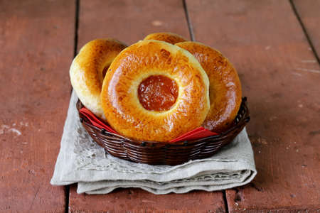round sweet buns with apple jam in a wicker basketの写真素材