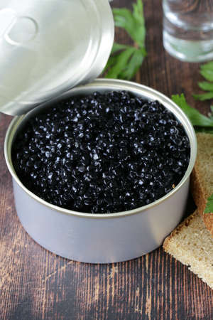 caviar with rye bread and two shots vodka on a wooden tableの写真素材