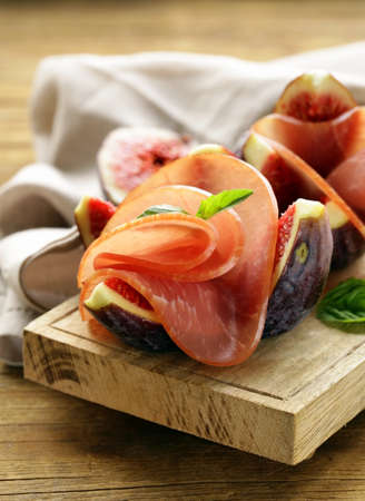 ripe purple figs with smoked ham - a traditional antipasti appetizerの写真素材