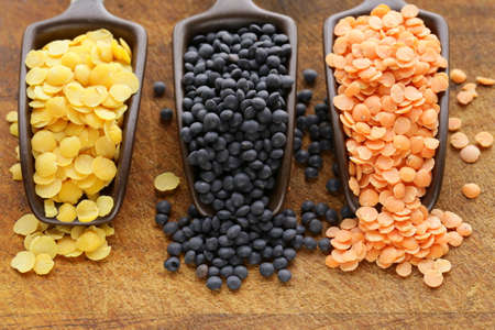 red, yellow and black lentils on a wooden background