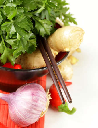 Asian style ingredients (ginger, chilli, coriander and garlic) in traditional utensilsの写真素材
